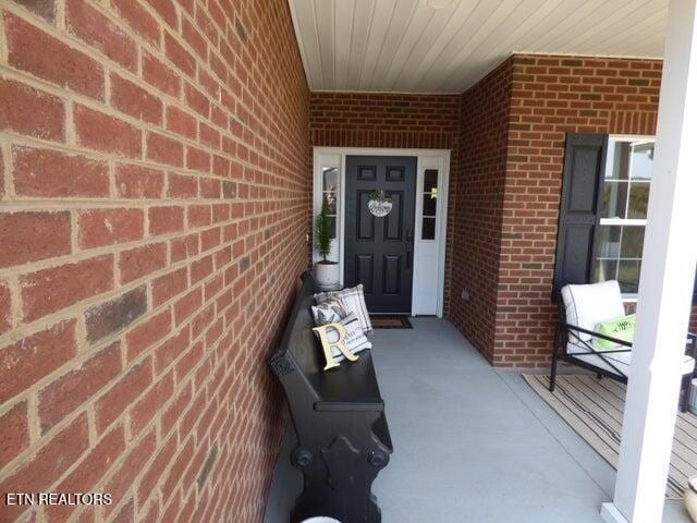 doorway to property featuring brick siding