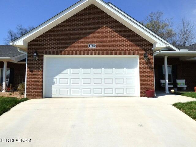 view of home's exterior featuring a garage, brick siding, and driveway
