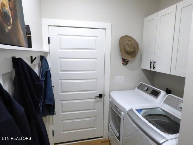 washroom featuring cabinet space and washing machine and clothes dryer