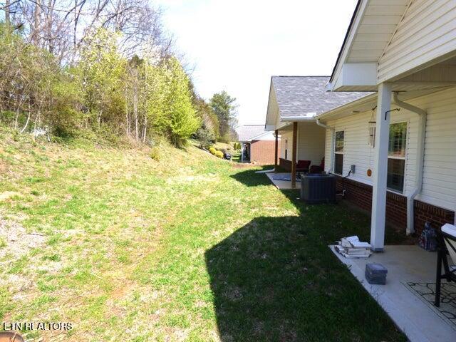 view of yard featuring cooling unit and a patio