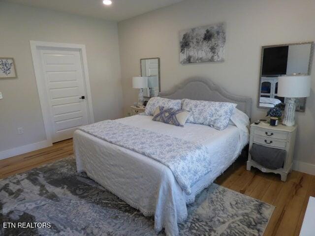 bedroom with wood finished floors, baseboards, and recessed lighting
