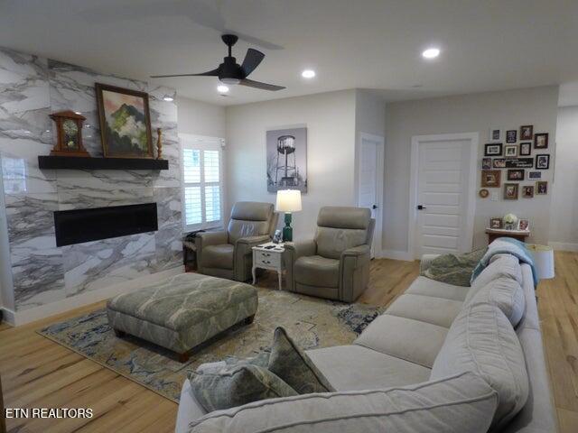 living room featuring recessed lighting, a ceiling fan, and wood finished floors