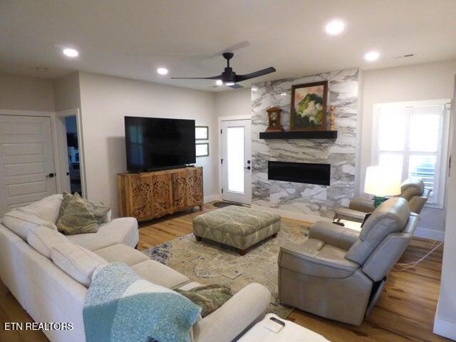 living area featuring a wealth of natural light, a ceiling fan, and wood finished floors