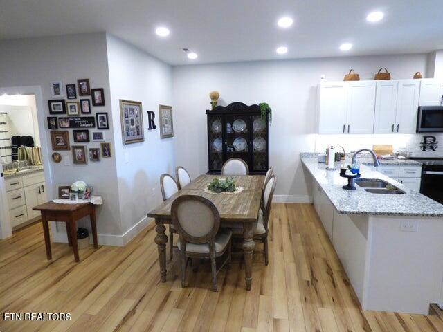 dining area with baseboards, recessed lighting, and light wood-style floors