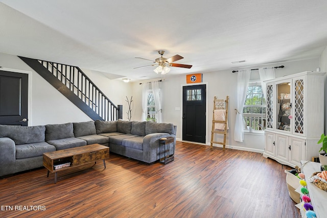 living room with ceiling fan, visible vents, wood finished floors, stairs, and baseboards