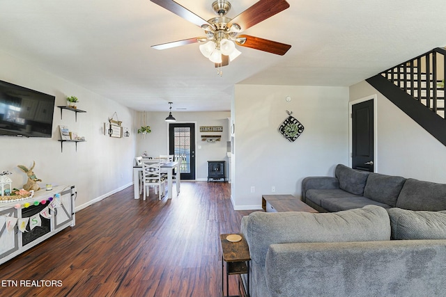 living area featuring ceiling fan, baseboards, and dark wood finished floors