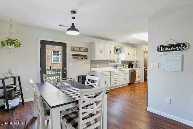 dining room with visible vents, baseboards, and dark wood-style floors