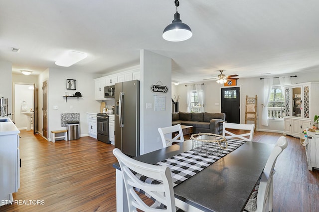 dining room with visible vents, baseboards, a ceiling fan, and wood finished floors