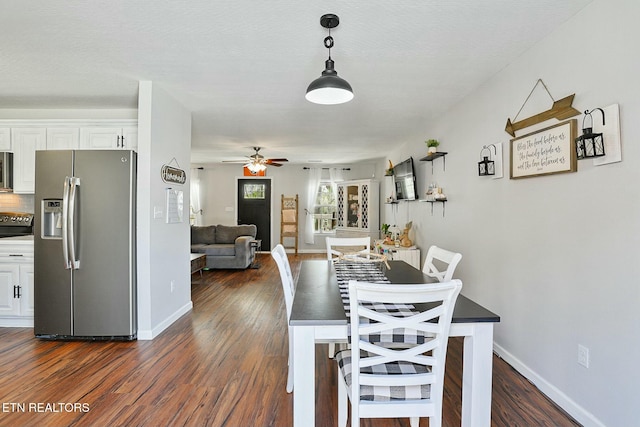 dining space with dark wood-type flooring, baseboards, and ceiling fan