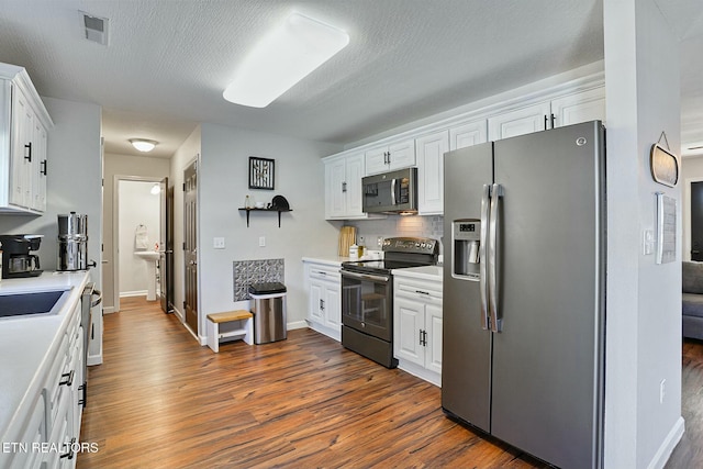 kitchen with white cabinets, appliances with stainless steel finishes, and visible vents