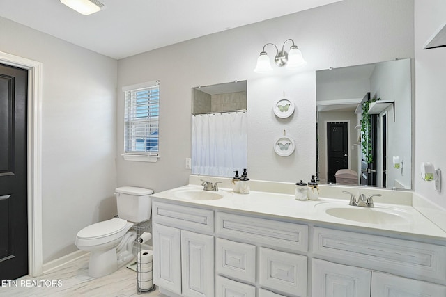 full bathroom with double vanity, a shower with curtain, a sink, and toilet