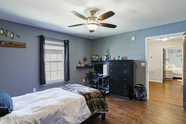 bedroom featuring visible vents, baseboards, a ceiling fan, and wood finished floors