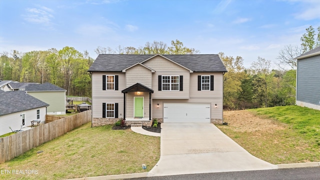 view of front of home featuring concrete driveway, stone siding, an attached garage, fence, and a front lawn
