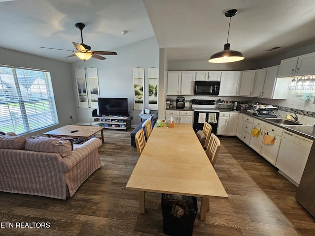 kitchen featuring range with electric cooktop, a sink, open floor plan, black microwave, and white cabinetry
