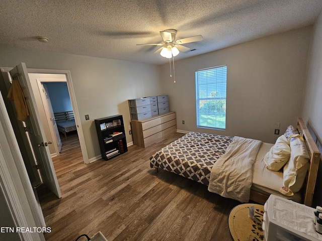 bedroom featuring baseboards, a ceiling fan, wood finished floors, and a textured ceiling