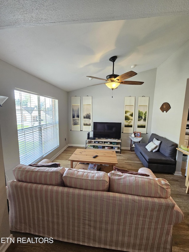 living room with a textured ceiling, a ceiling fan, wood finished floors, lofted ceiling, and baseboards