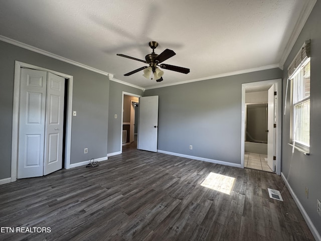 unfurnished bedroom with crown molding, visible vents, baseboards, and dark wood-style floors
