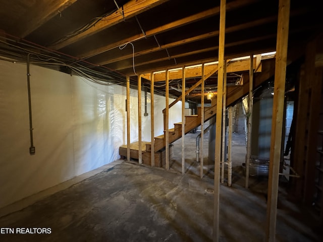 unfinished basement featuring stairs