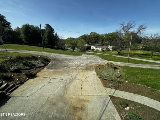 surrounding community with a yard and curved driveway