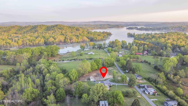 aerial view with a wooded view and a water view