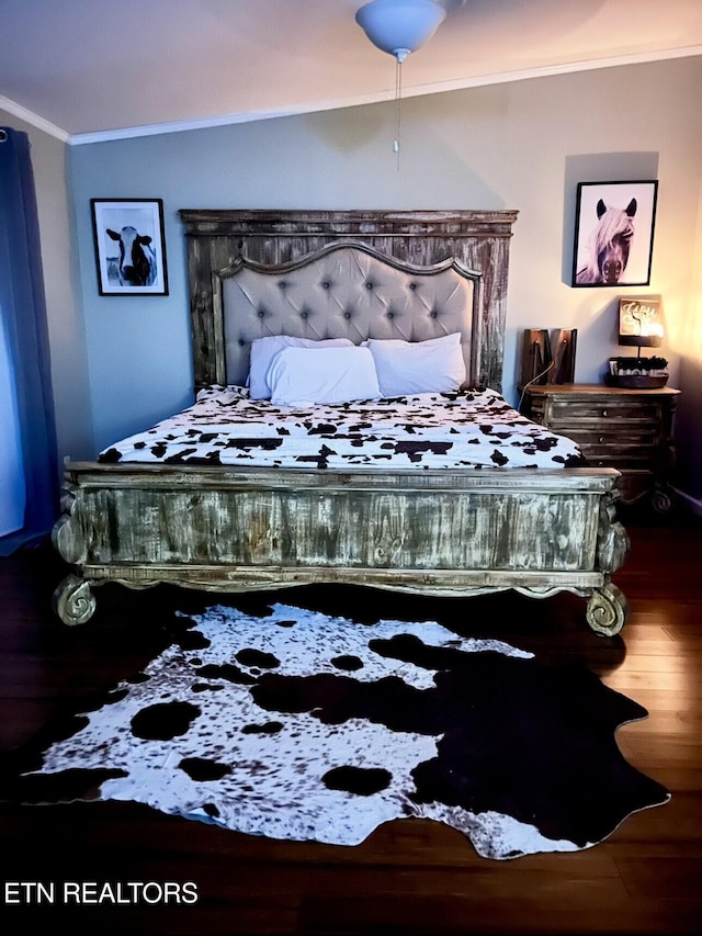 bedroom featuring wood finished floors and crown molding