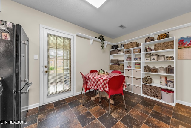 dining area with visible vents, baseboards, and stone tile floors