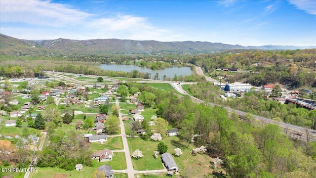 birds eye view of property featuring a wooded view and a water and mountain view