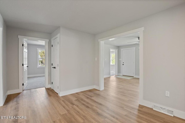 interior space featuring light wood-style floors, baseboards, and visible vents