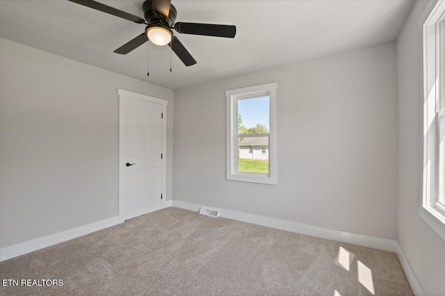 unfurnished room featuring visible vents, baseboards, ceiling fan, and carpet