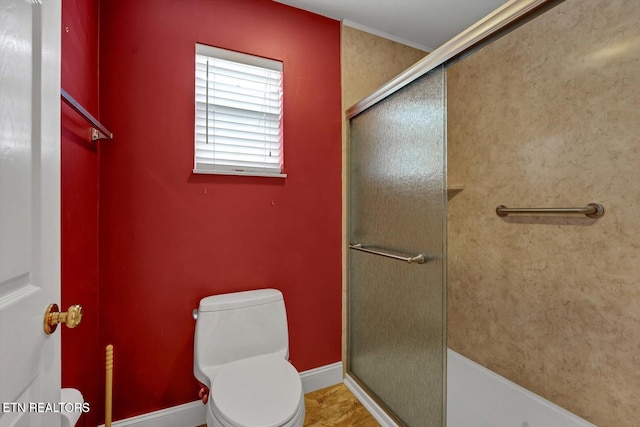 full bath featuring toilet, a shower stall, and baseboards