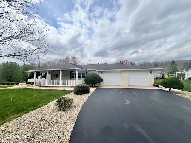 view of front of home with driveway, an attached garage, a front yard, ceiling fan, and covered porch