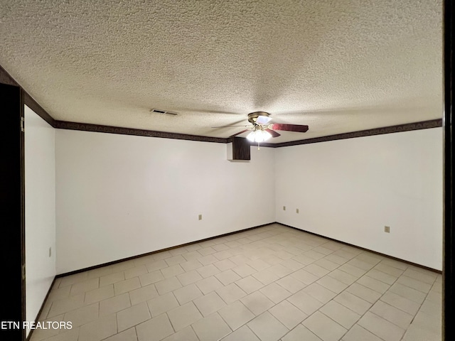 spare room featuring visible vents, baseboards, a ceiling fan, and a textured ceiling