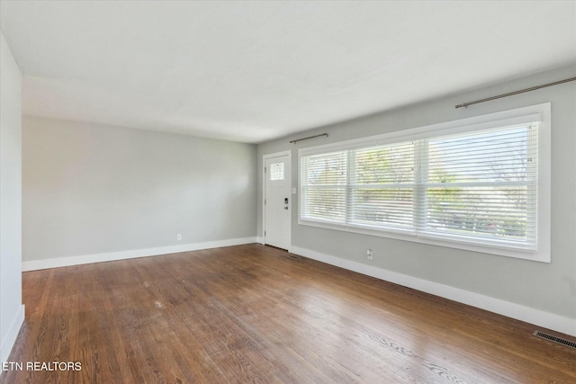 interior space with visible vents, baseboards, and wood finished floors