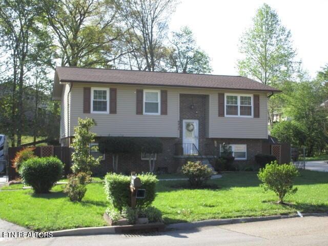 bi-level home with brick siding and a front lawn