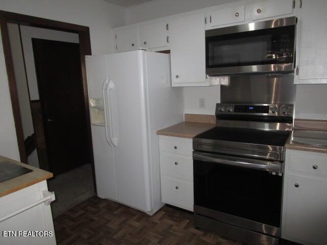 kitchen featuring stainless steel appliances and white cabinetry