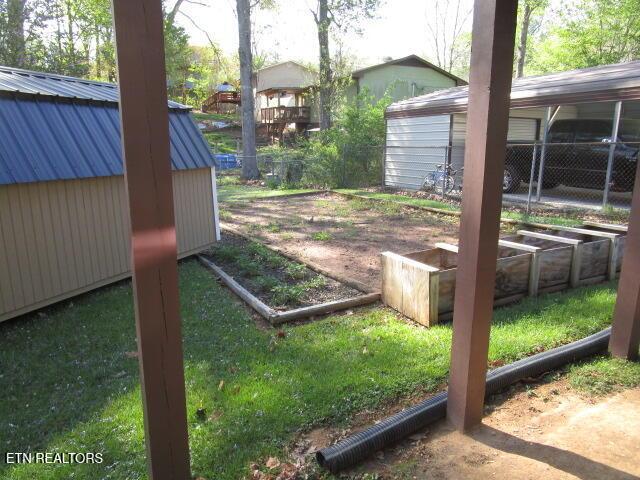 view of yard featuring a garden, a shed, and an outdoor structure