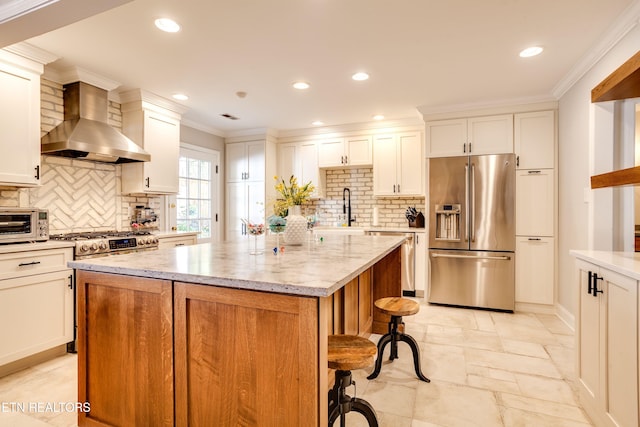 3835 SW Keowee Ave, Knoxville, TN 37919 - kitchen featuring stone tile floors, wall chimney range hood, a kitchen island, a sink, and stainless steel appliances