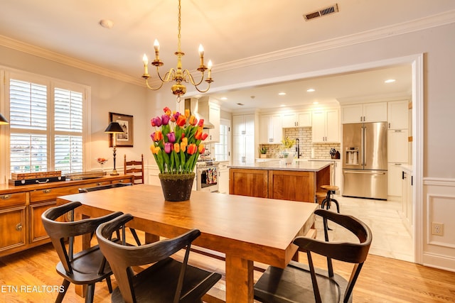 3835 SW Keowee Ave, Knoxville, TN 37919 - dining room with crown molding, visible vents, light wood-type flooring, and a chandelier