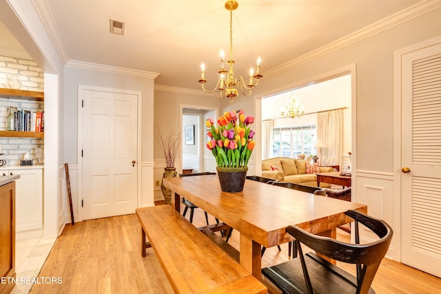 3835 SW Keowee Ave, Knoxville, TN 37919 - dining room featuring light wood-style flooring, an inviting chandelier, crown molding, and wainscoting
