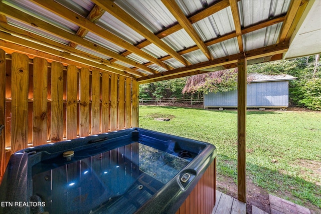 wooden terrace featuring a lawn, fence, and a hot tub