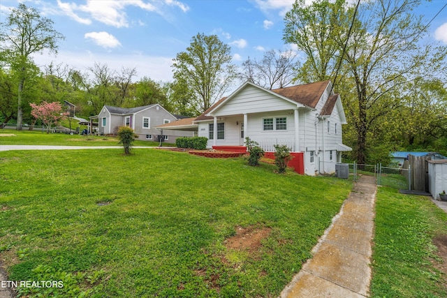 view of front of home with driveway, cooling unit, a front lawn, an attached carport, and fence