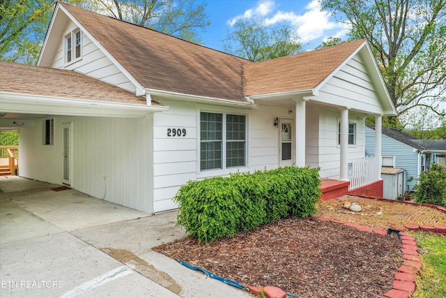 view of front of house featuring a carport, a porch, and a shingled roof