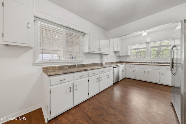 kitchen featuring stainless steel dishwasher, dark wood-type flooring, white cabinetry, and freestanding refrigerator