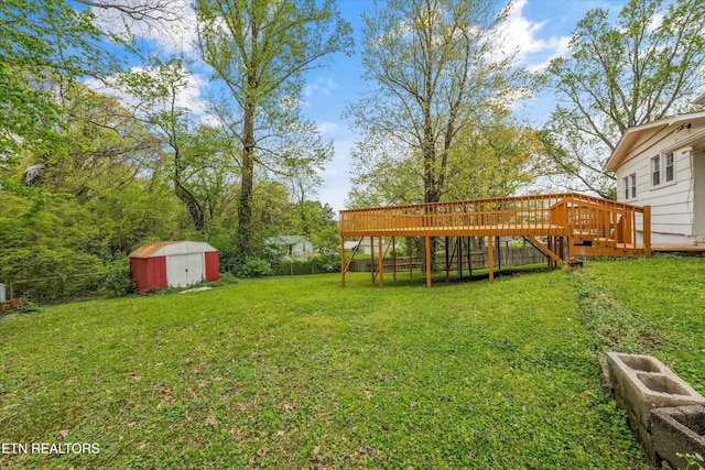 view of yard featuring a deck, an outbuilding, and a storage unit