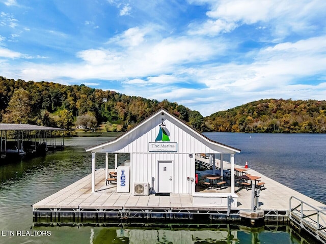 dock area featuring a view of trees, ac unit, and a water view