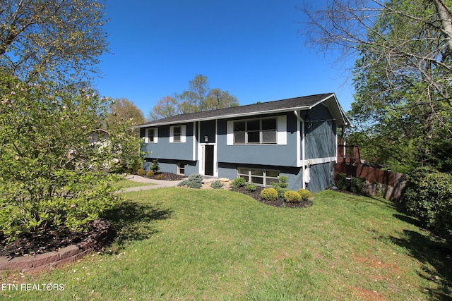 split foyer home featuring fence and a front lawn
