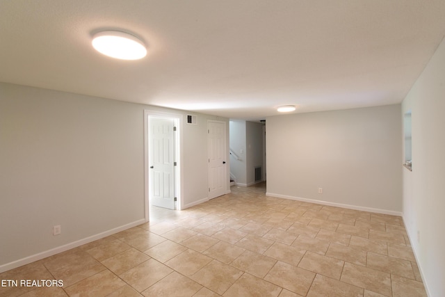 unfurnished room with light tile patterned flooring, baseboards, and visible vents