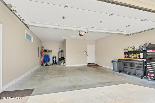 garage featuring electric water heater, baseboards, and a garage door opener