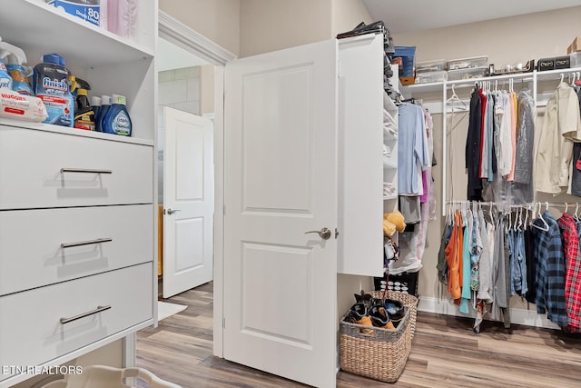 walk in closet with wood finished floors