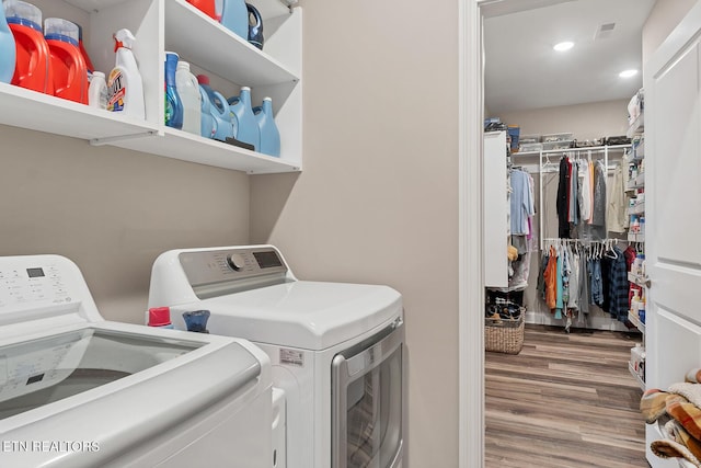 washroom with laundry area, separate washer and dryer, visible vents, recessed lighting, and wood finished floors